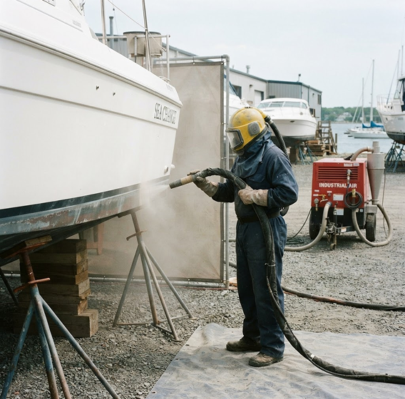 Technician performing surface preparation blasting on site